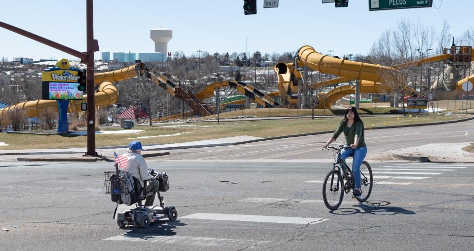 Bicyclist and wheelchair user crossing Pecos Street near WaterWorld