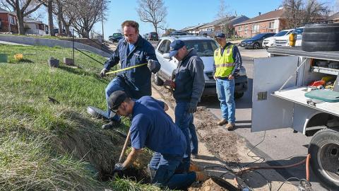 Four employees working on a meter setter repair.
